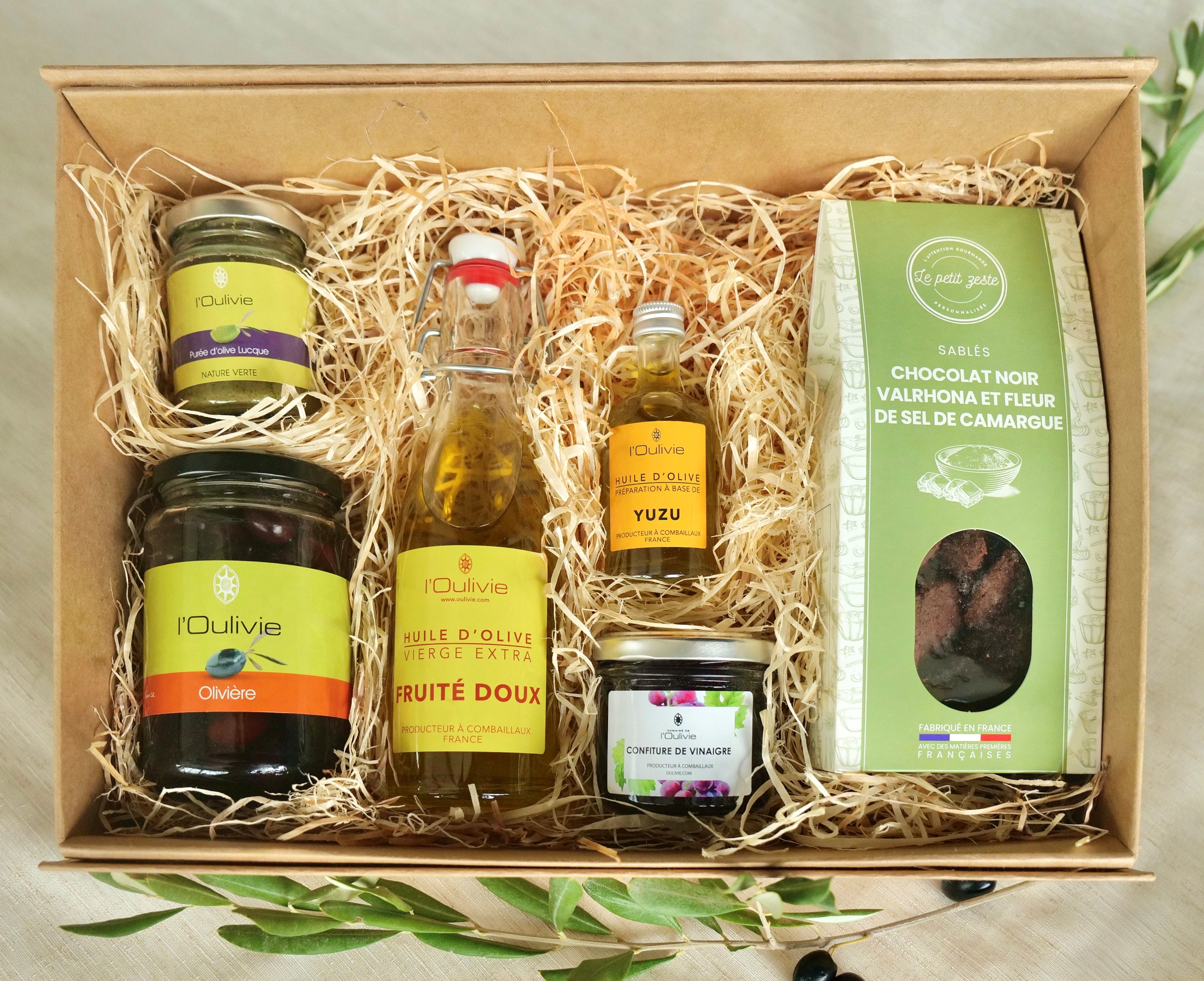 Coffret Gourmand du Domaine l'Oulivie composé de : huiles d'olive, olives, purée d'olive, confiture de vinaigre et petits biscuits sucrés.